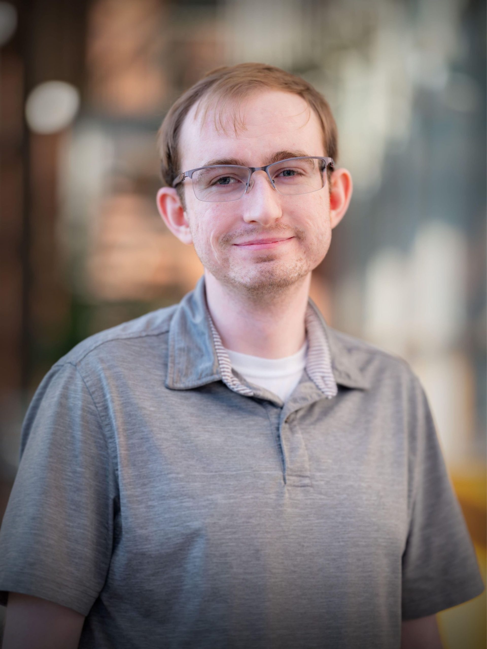 Portrait of a man in glasses and a grey polo, representing Mined XAI’s human-centered approach to explainable AI solutions.