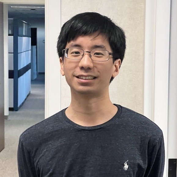 Smiling Mined XAI team member wearing glasses and a dark shirt, reflecting our human-centered approach to explainable AI.